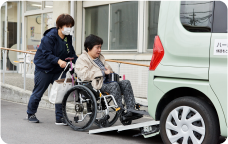 車いすのご利用者を送迎車へお連れしている画像